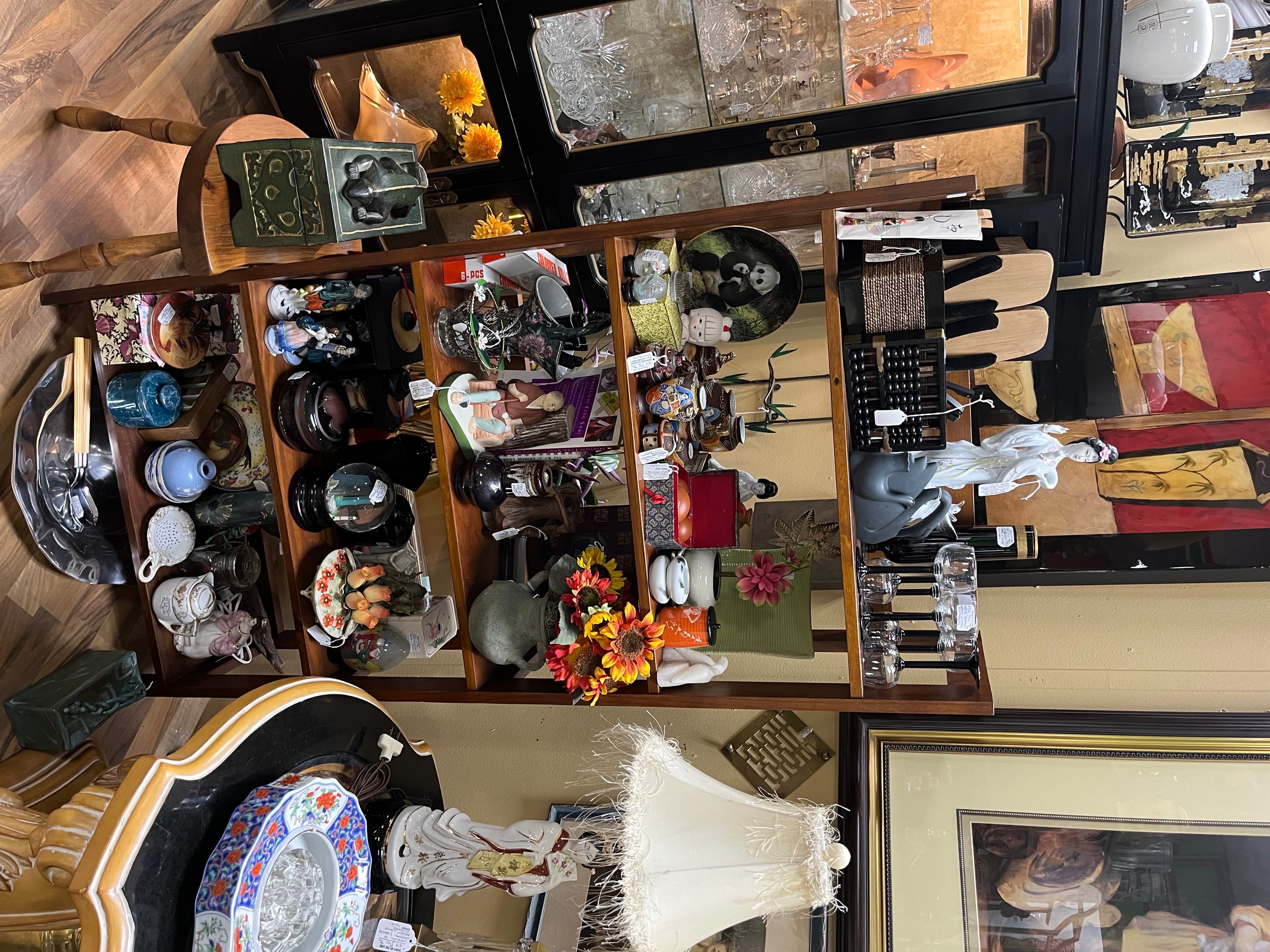 Wooden display case at the Silk Purse Sisters booth, full of small figurines, lamps, and oddities.